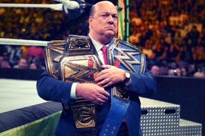 Paul Heyman segurando cinturões de Roman Reings