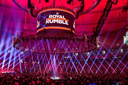 Arena lotada com palco iluminado e telão do Royal Rumble antes do início do evento — imagem ilustrando todos os vencedores do Royal Rumble.